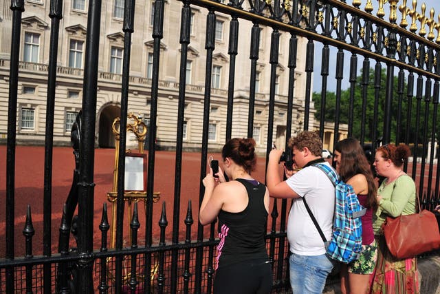 People queue to see the Easel displaying the Royal Birth announcement letter at Buckingham Palace