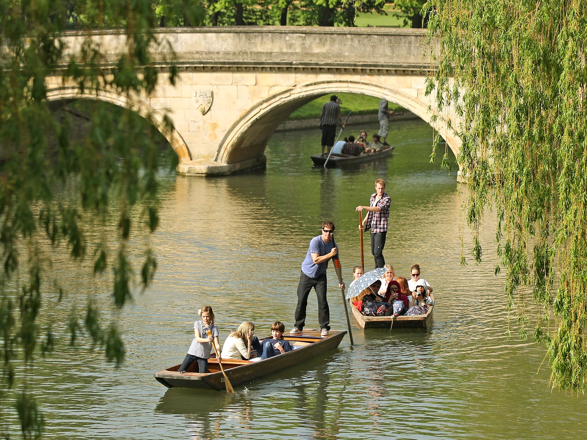 Members of the public punt along the river Cam in front of the colleges of Cambridge University
