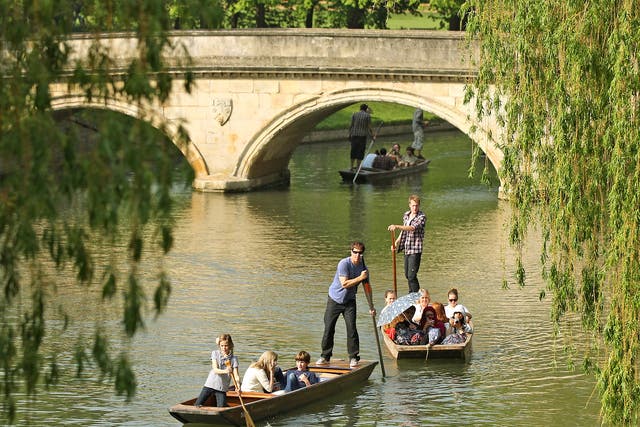 Members of the public punt along the river Cam in front of the colleges of Cambridge University 