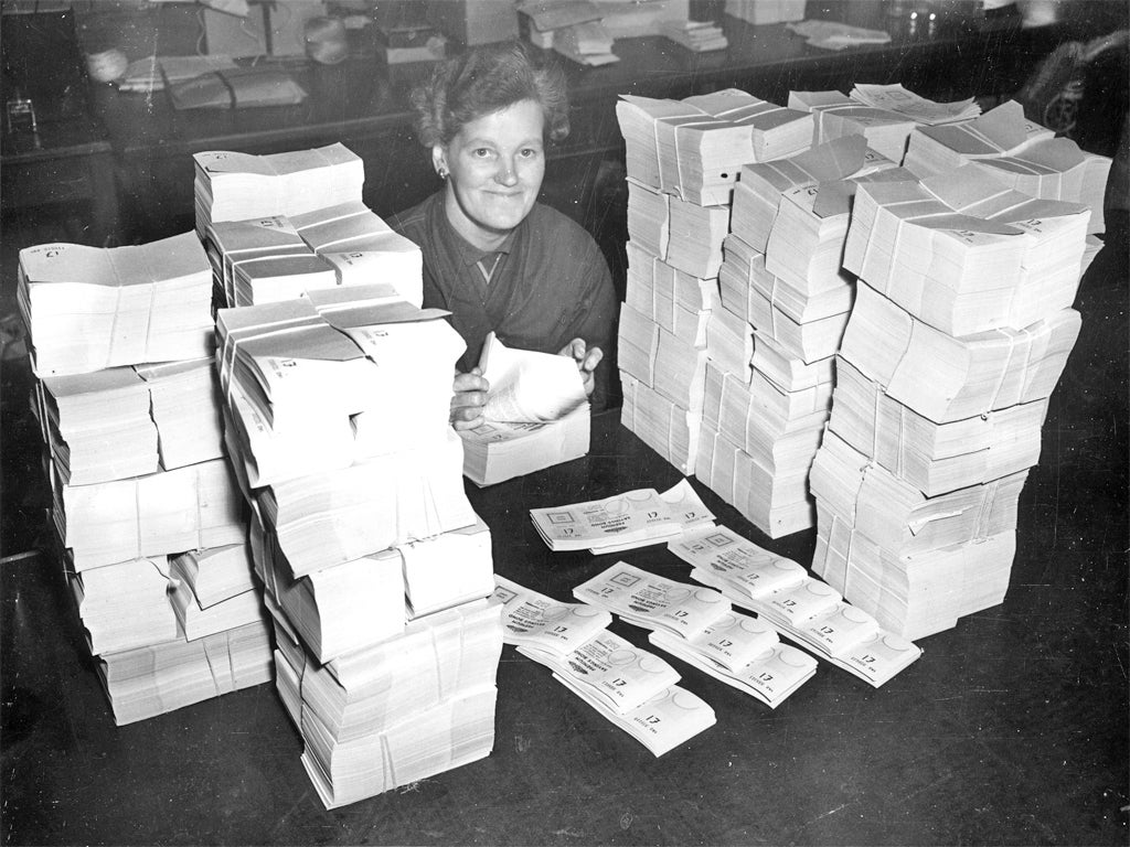 A worker counts one pound denomination premium bonds at a Post Office distribution centre in 1956