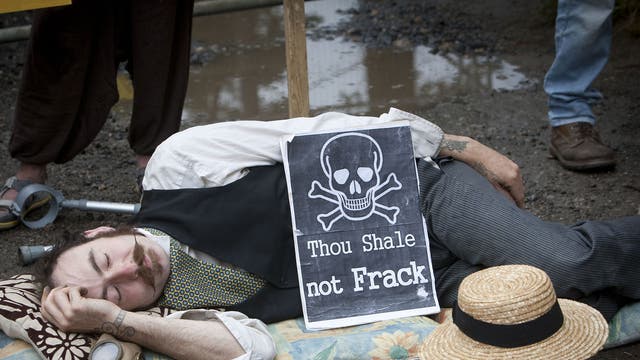 A protestor lies down in front of the entrance gate