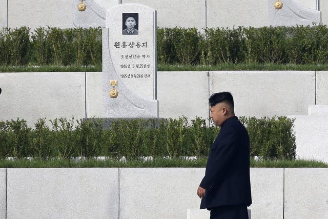 Kim Jong-un walks past tombstones at the opening of the Cemetery of Fallen Fighters in Pyongyang