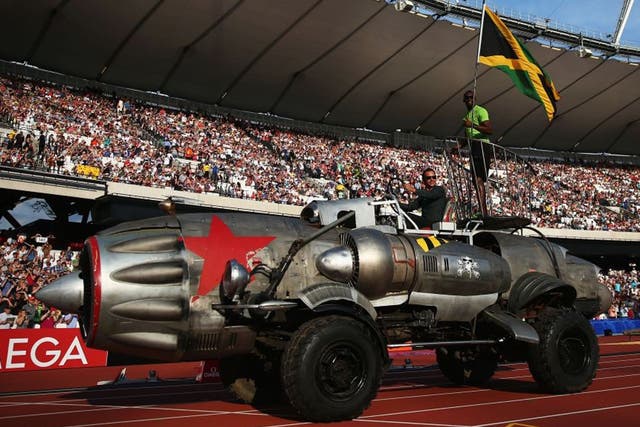 Usain Bolt with a Jamaica flag arrives in the Olympic Stadium in typically flamboyant style aboard a jet engine car