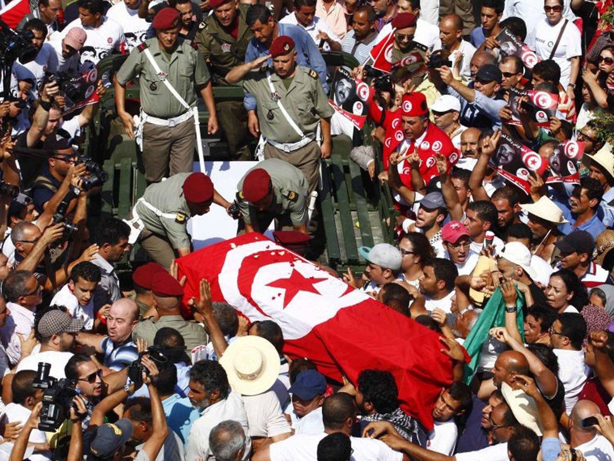 Mourners carry the coffin of murdered opposition leader Mohamed Brahmi during his funeral procession on Saturday