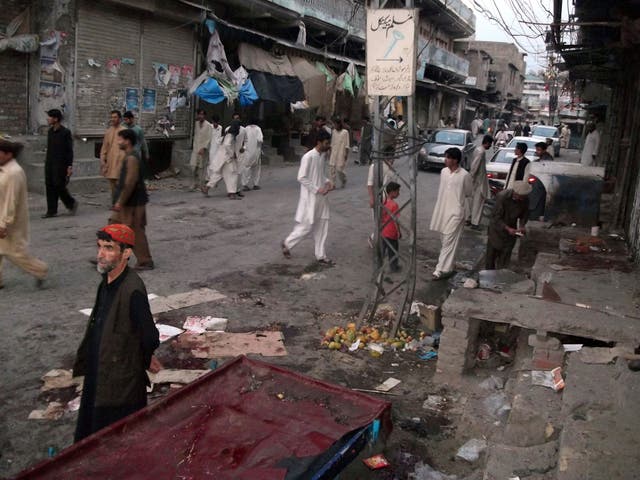 Pakistani residents gather at the site of twin bomb explosions in Parachinar, the main town of Kurram tribal district