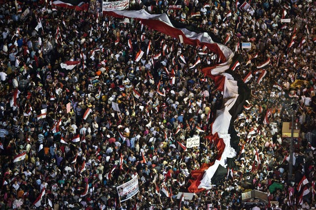 Supporters of Egyptian Armed Forces General Ahmed Fattah al-Sisi wave national flags as they rally at Tahrir Square