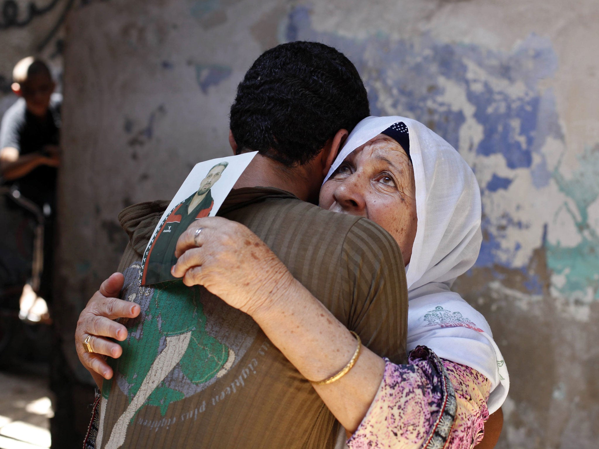 The mother of Palestinian Ateya Abu Moussa, who has been held prisoner by Israel for 20 years, hugs her grandson upon hearing the news that her son may soon be released