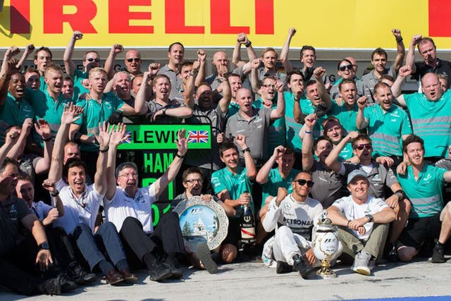 Lewis Hamilton, centre, celebrates with his Mercedes team following his first win for the outfit (Peter J Fox/Getty Images)