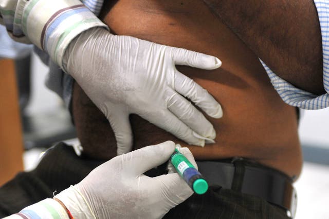 A medical assistant administers an insulin shot to a diabetes patient at a private clinic in New Delhi on November 8, 2011.