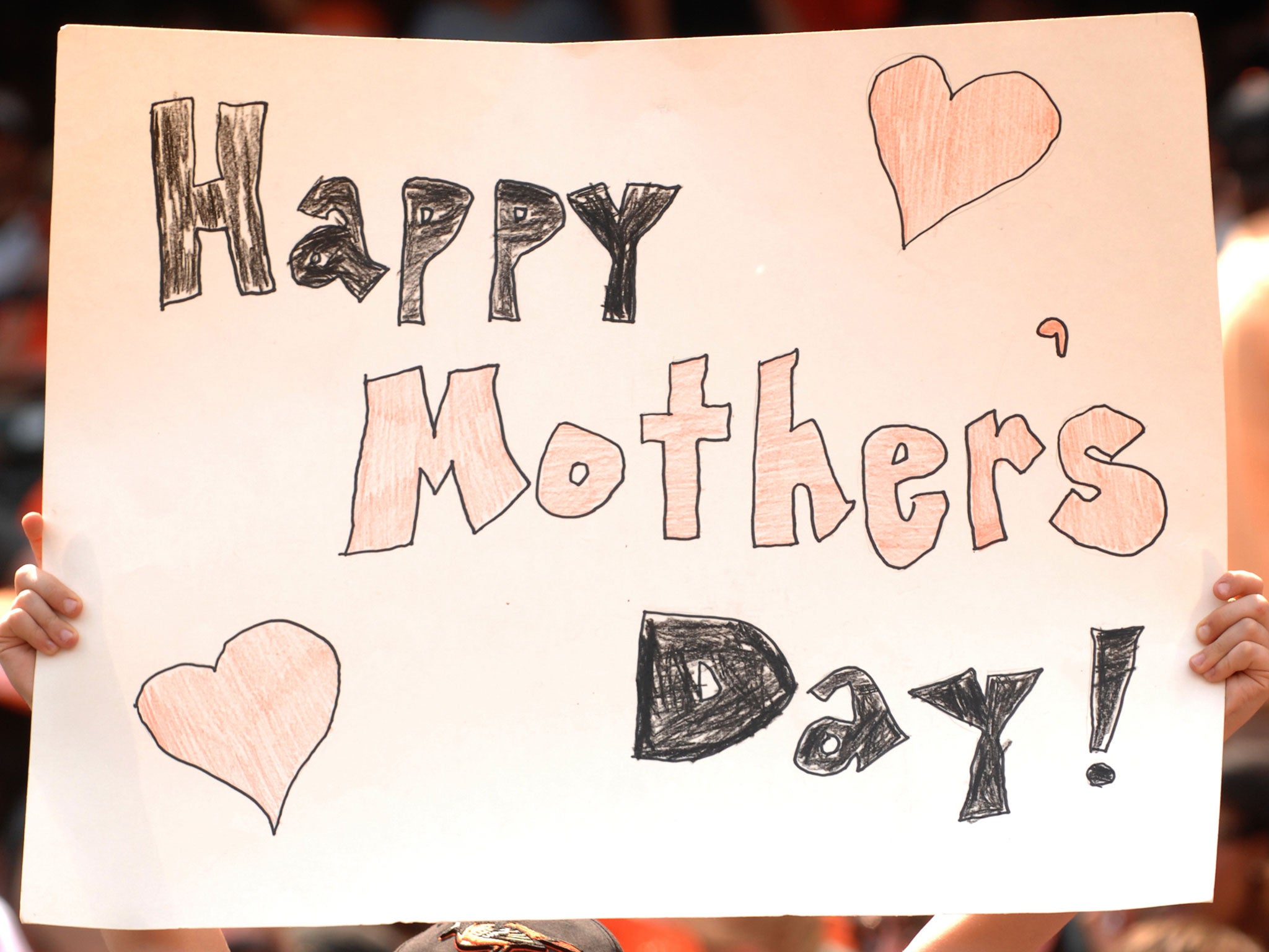 A Baltimore Orioles fan holds up a Mother's Day sign during a baseball game against the Tampa Bay Rays at Oriole Park at Camden Yards on May 13, 2012 in Baltimore, Maryland.