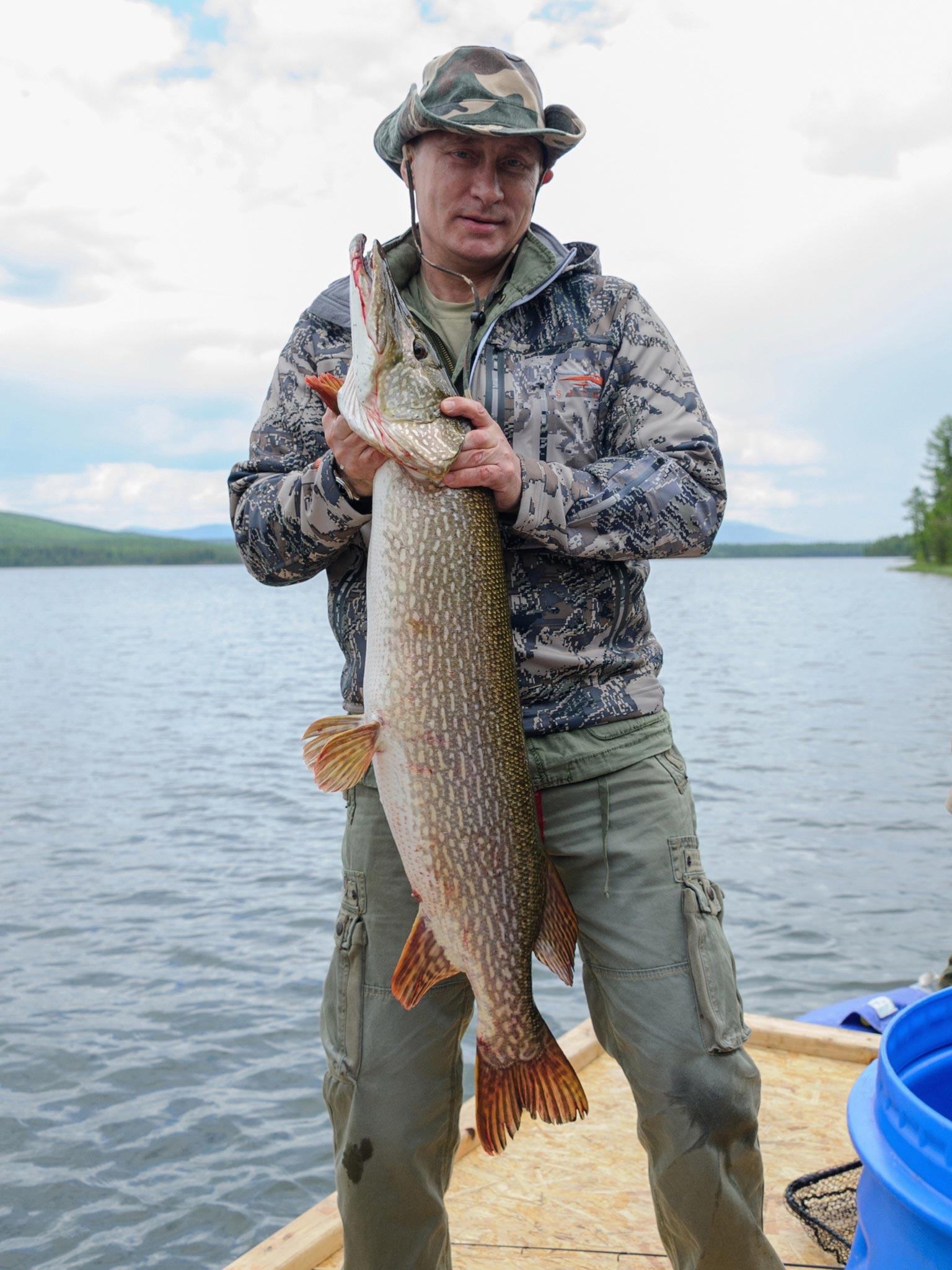 Russian President Vladimir Putin holding a huge pike fish, after he caught it in the Tyva during his holiday