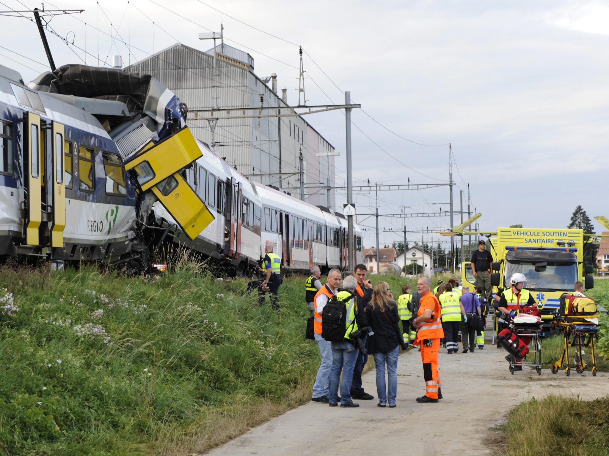 Rescue workers tend to the scene of a train collision in Granges-pres-Marnand in Western Switzerland