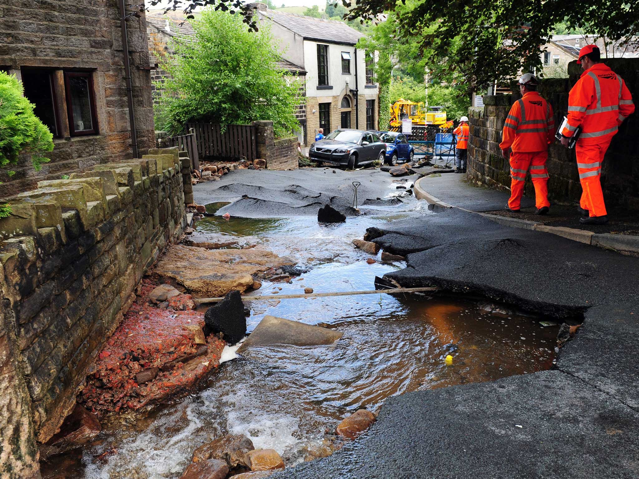 Engineers examine the damage left by flash floods in Walsden, near Todmorden