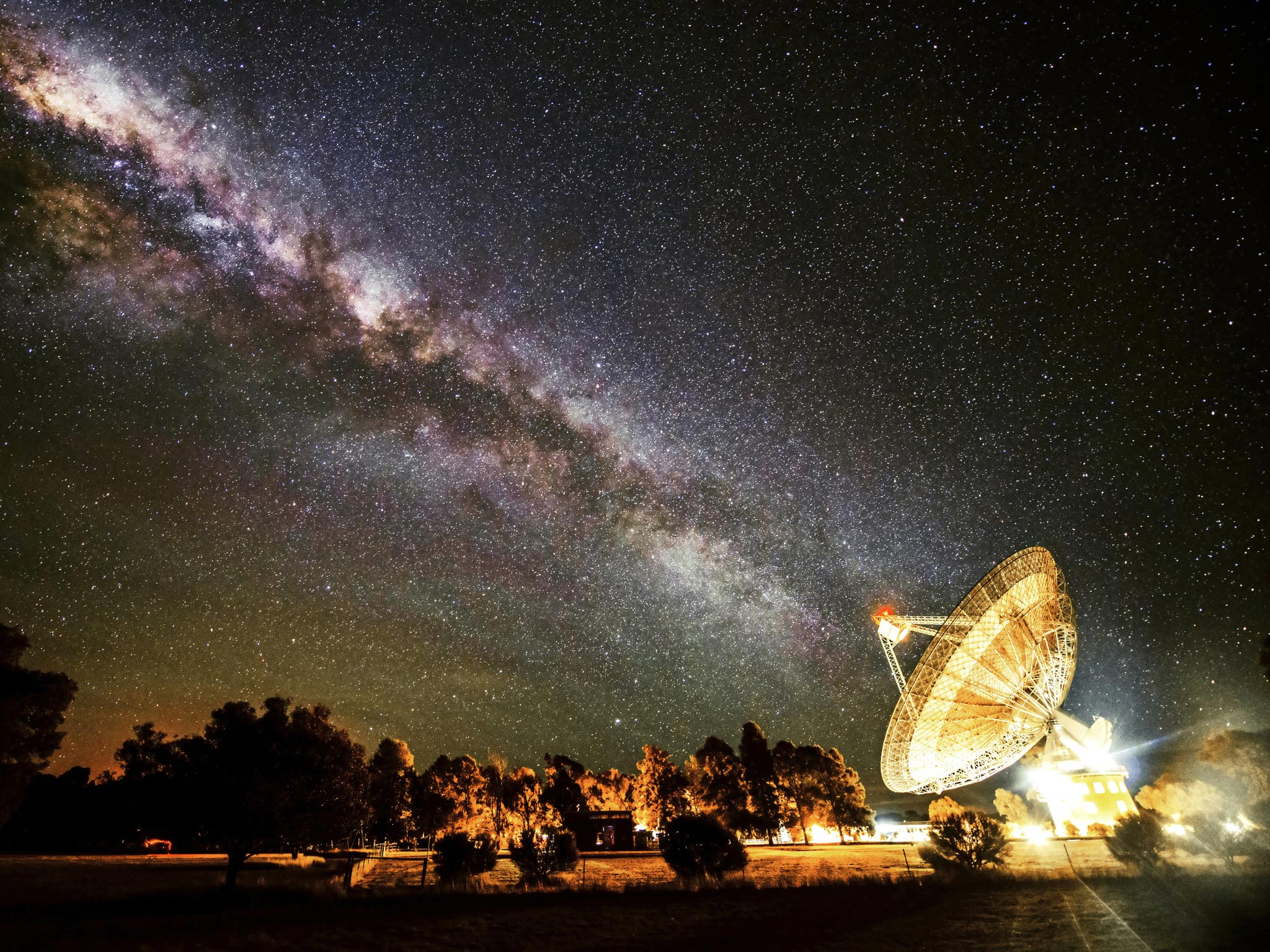 Receiving the Galactic Beam by Wayne England (Australia):
The photographer has managed to catch the moment when the Milky Way appears to line up with the giant 64m dish of the radio telescope at Parkes Observatory in Australia. As can be seen from the art