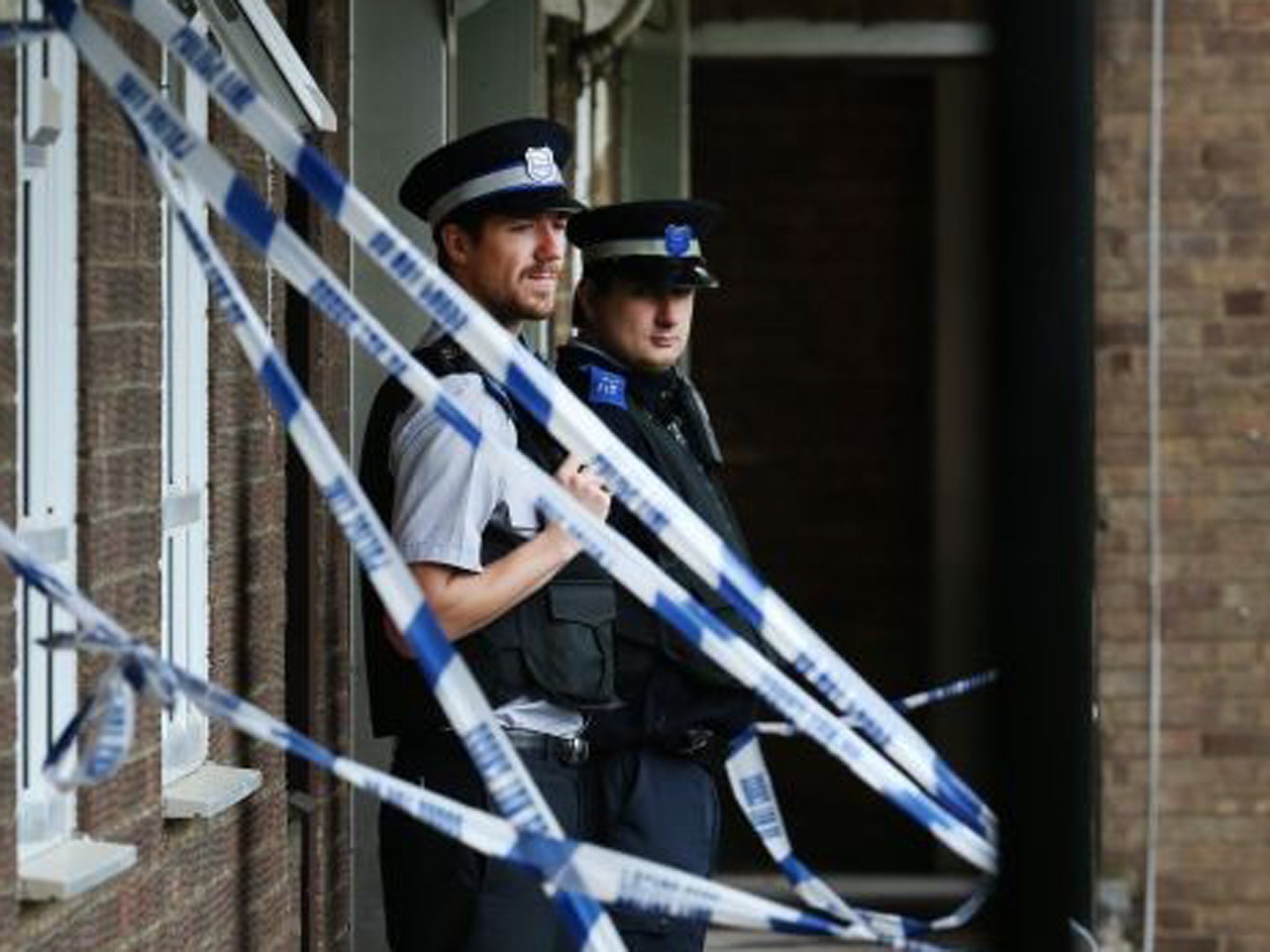 Community support officers stand guard at an address in Elstead House where police are investigating a stabbing incident