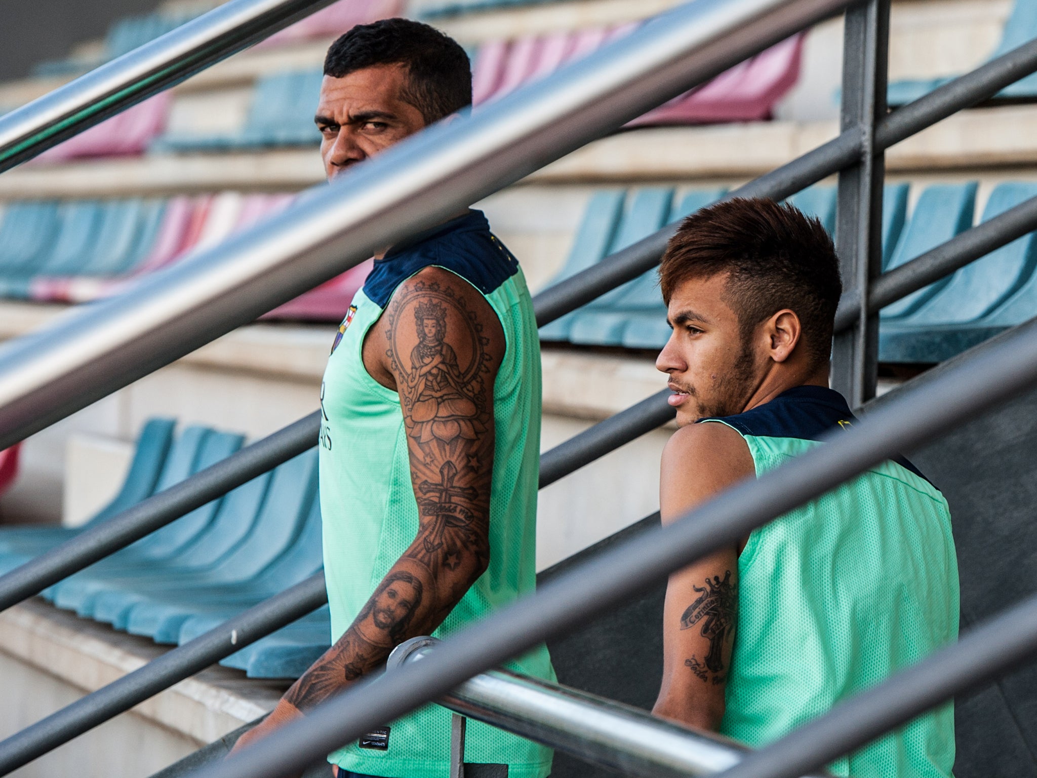 Neymar takes a break with Barcelona team-mate Dani Alves as two observe training from the stands