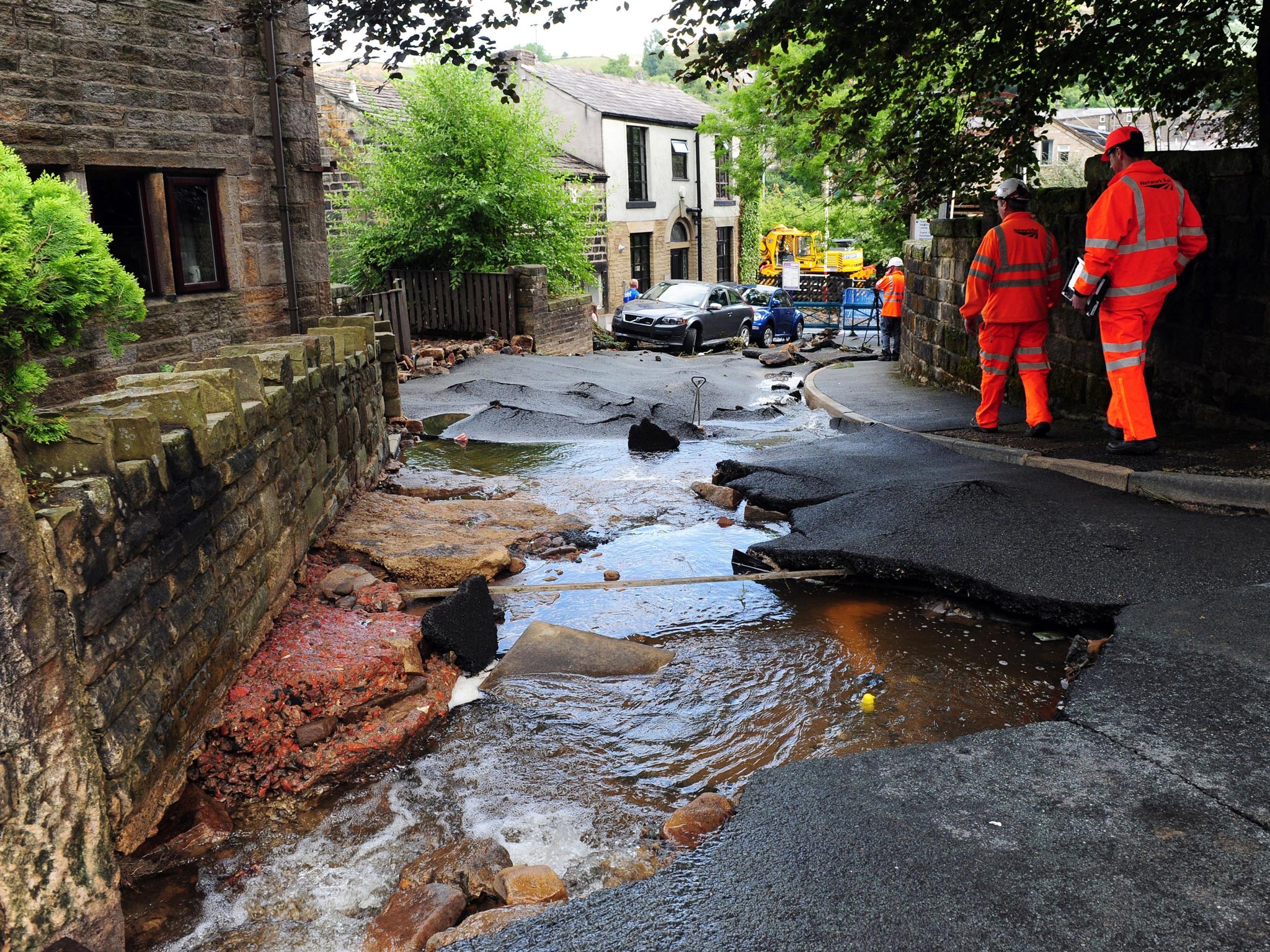 Engineers examine the damage left by flash floods in Walsden, near Todmorden, West Yorkshire