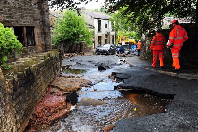 Engineers examine the damage left by flash floods in Walsden, near Todmorden, West Yorkshire