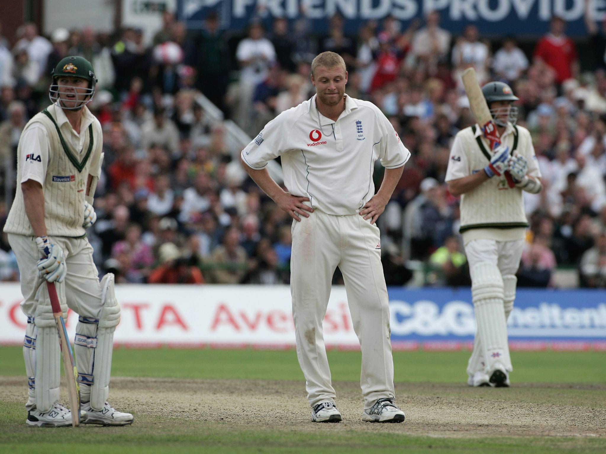 Andrew Flintoff of England looks dejected as Brett Lee (L) and Glenn McGrath hold on in 2005