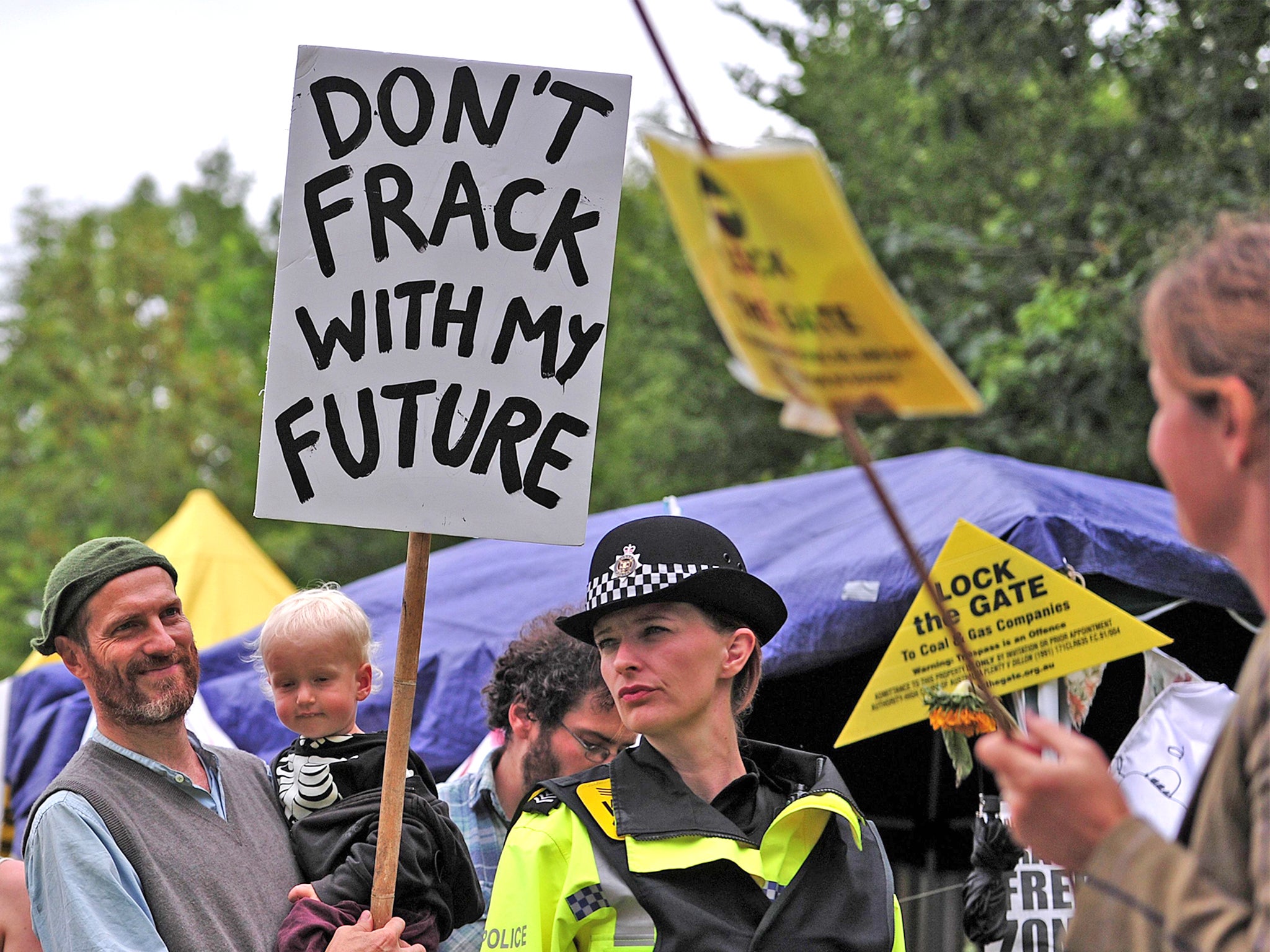 Police monitor protesters standing near to the entrance of a drill site in Balcombe, last July