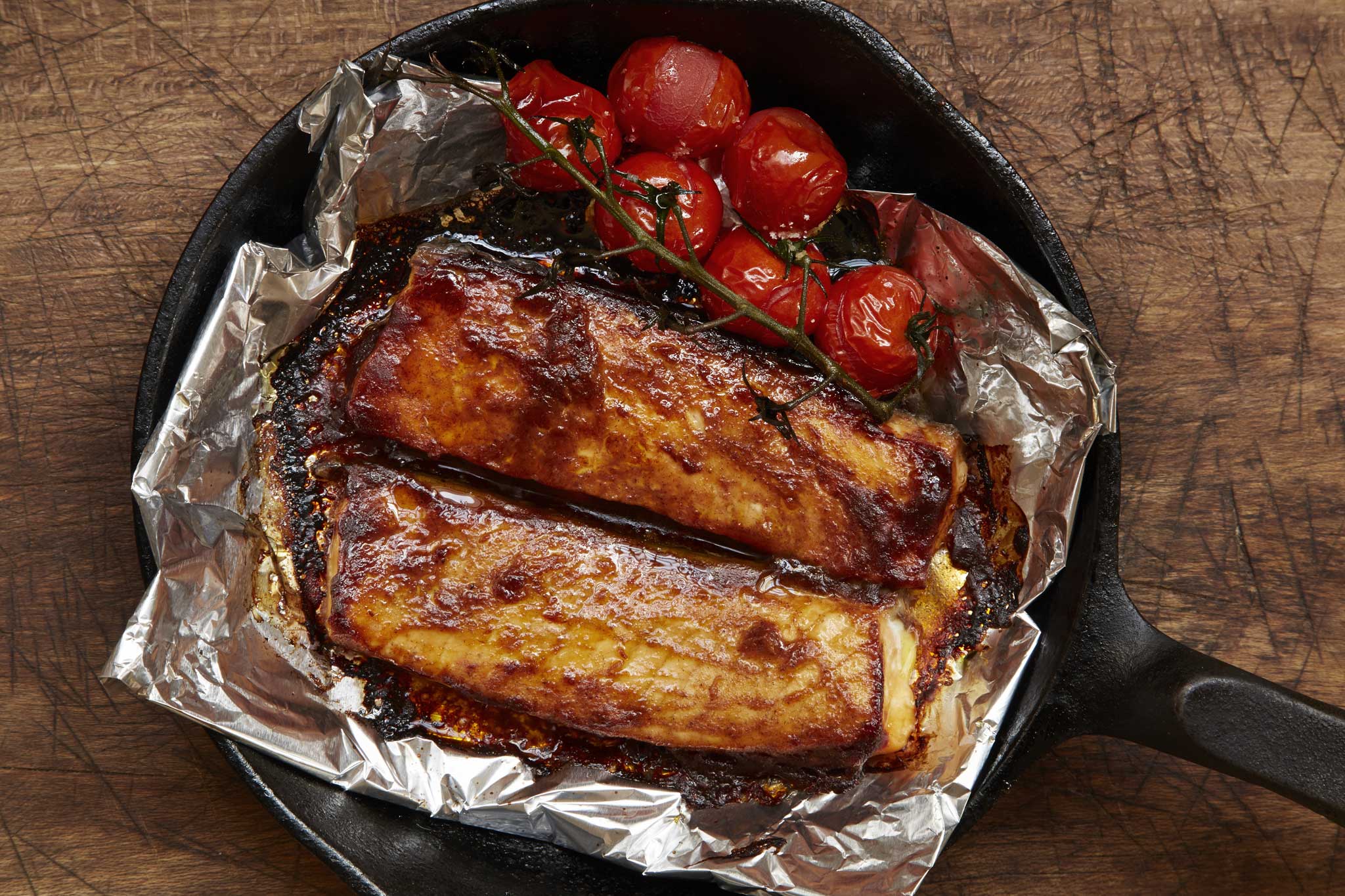 Barbecue-style salmon belly with roast cherry vine tomatoes