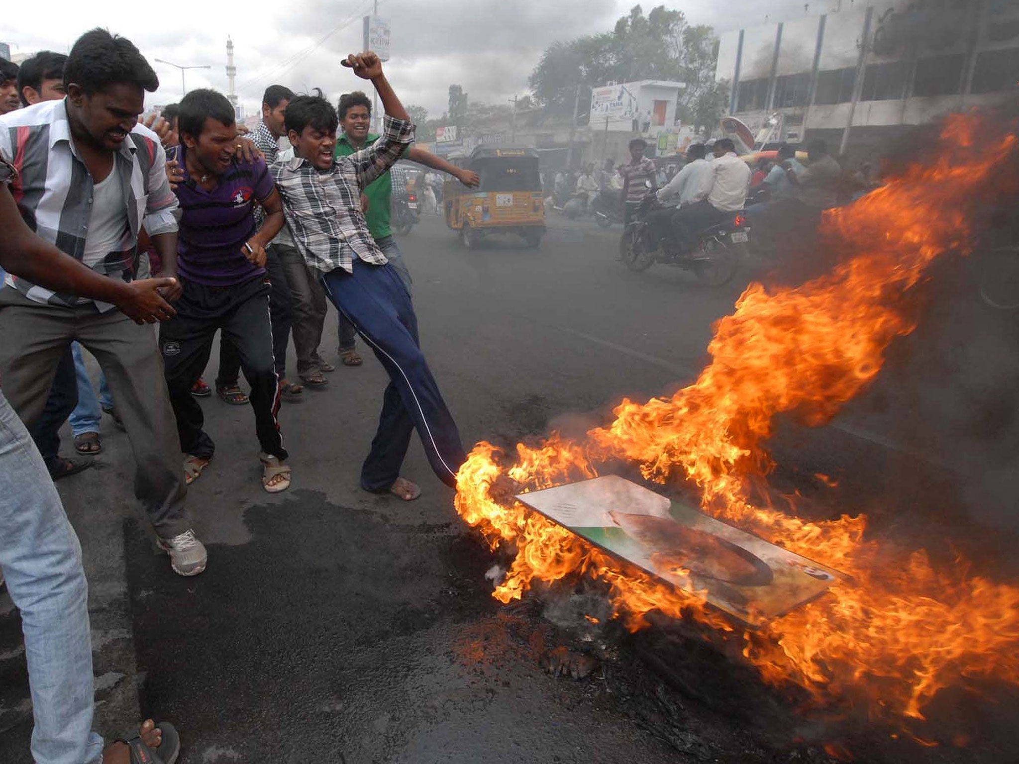 United Andhra Pradesh activists burn a portrait of former Indian Prime Minister Rajiv Gandhi in Ananthapur