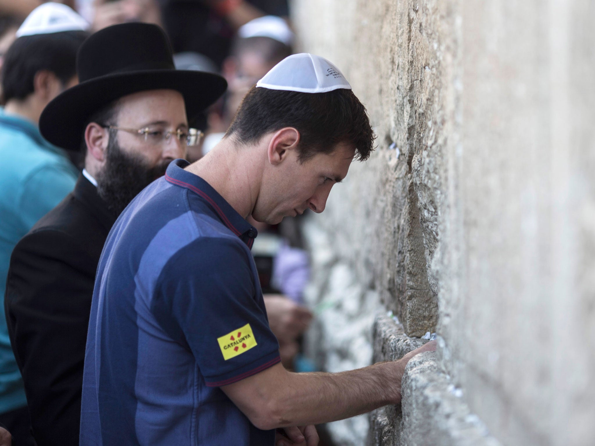 Barcelona footballer Lionel Messi places a wish on Jerusalem’s Western Wall