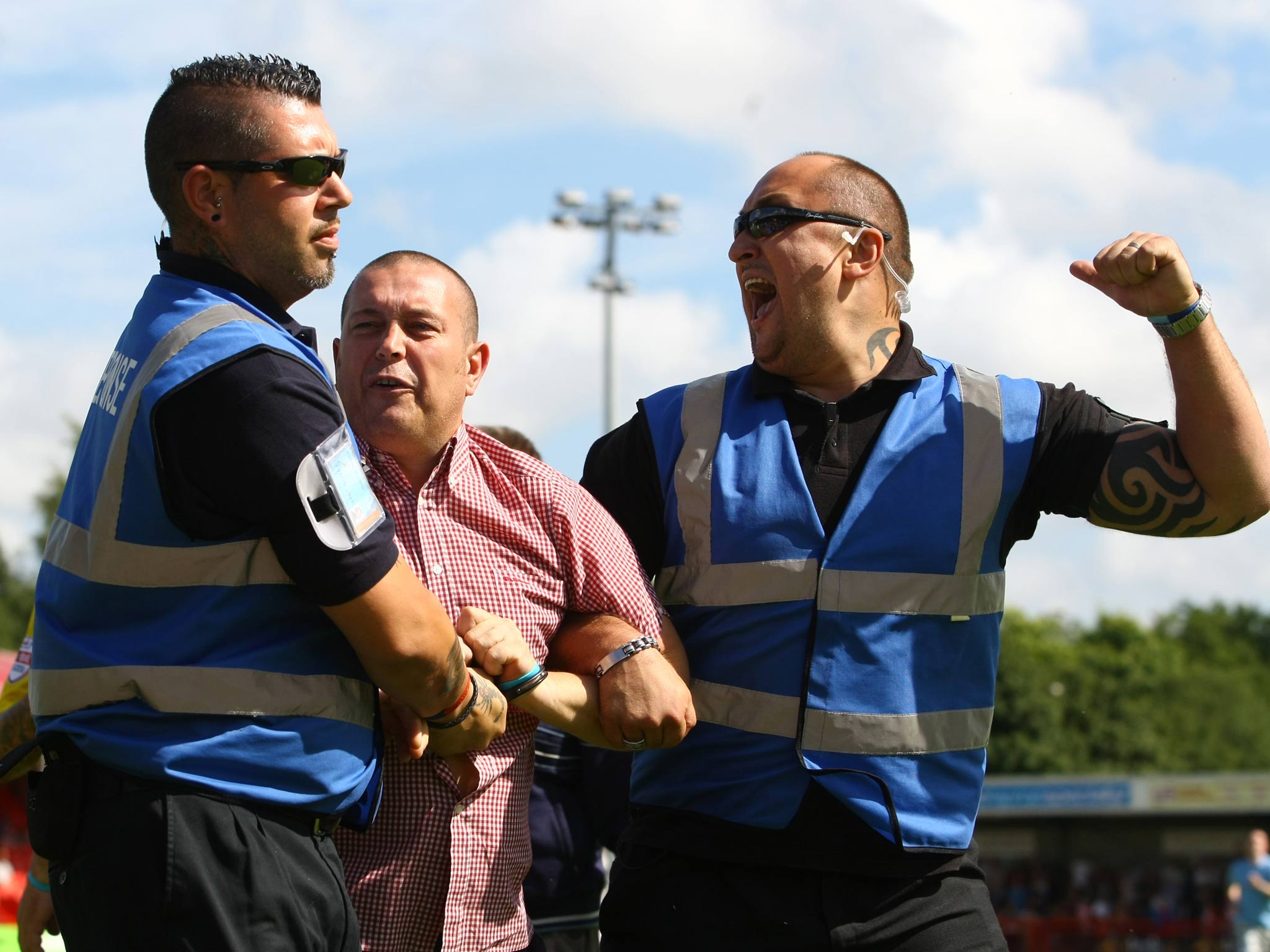 A Coventry City supporter is restrained by security after a pitch-invasion during the Sky Bet League One match against Crawley Town