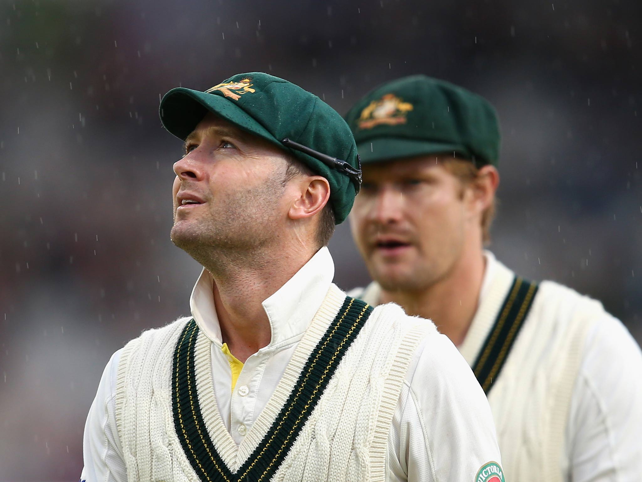 Michael Clarke and Shane Watson of Australia leave the ground after rain stopped play