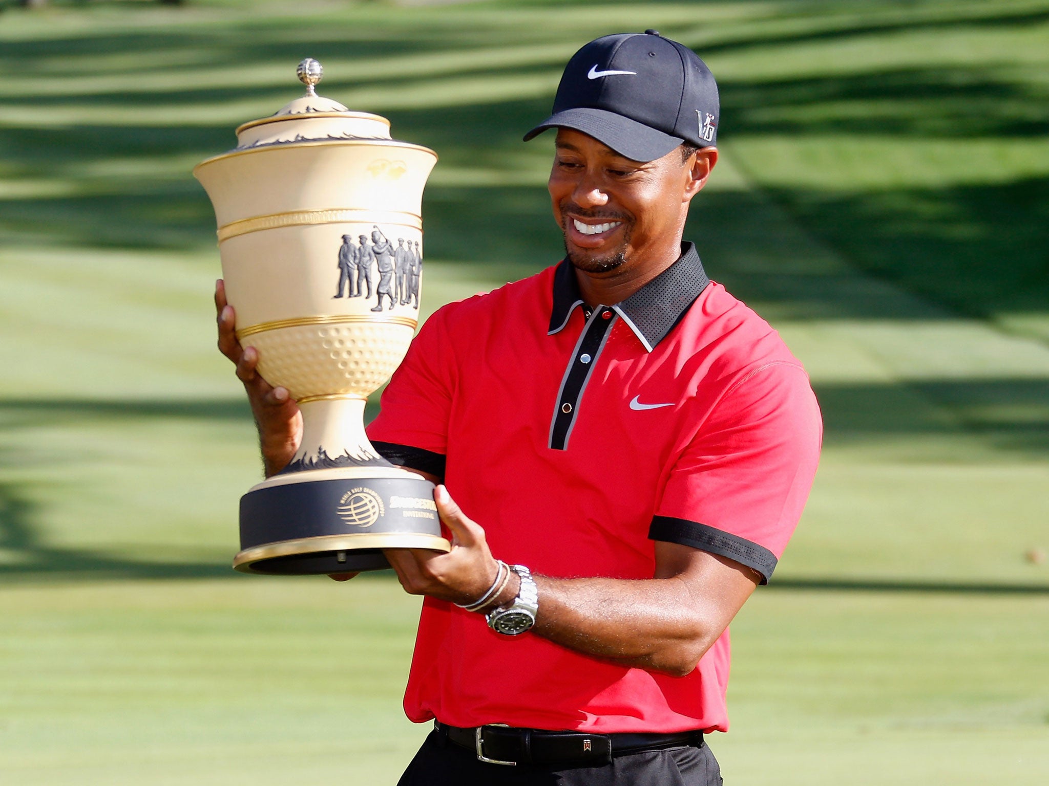 Tiger Woods shows off the trophy after his eighth Invitational win