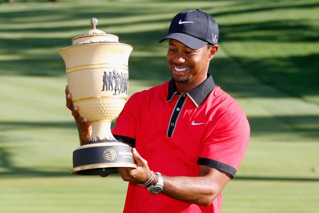 Tiger Woods shows off the trophy after his eighth Invitational win 