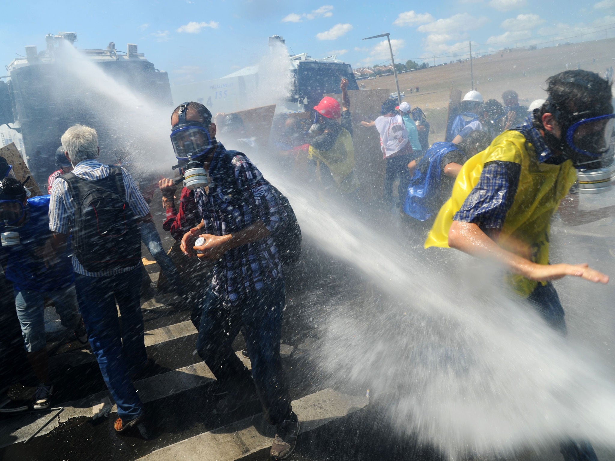 Demonstrators are hit by water cannon during clashes against Turkish police forces