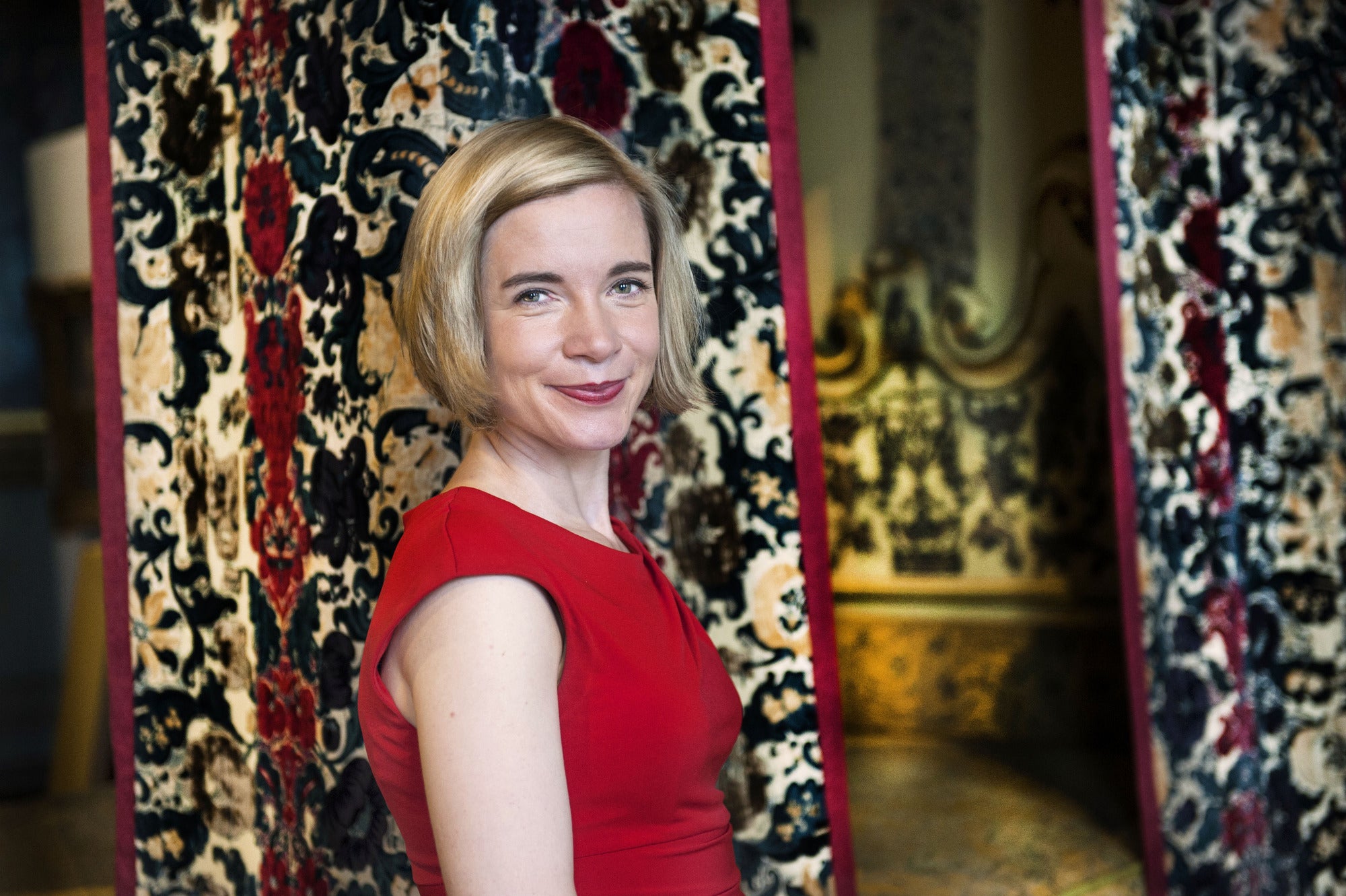 Lucy Worsley at Hampton Court Palace beside Mary of Moderna’s Bed