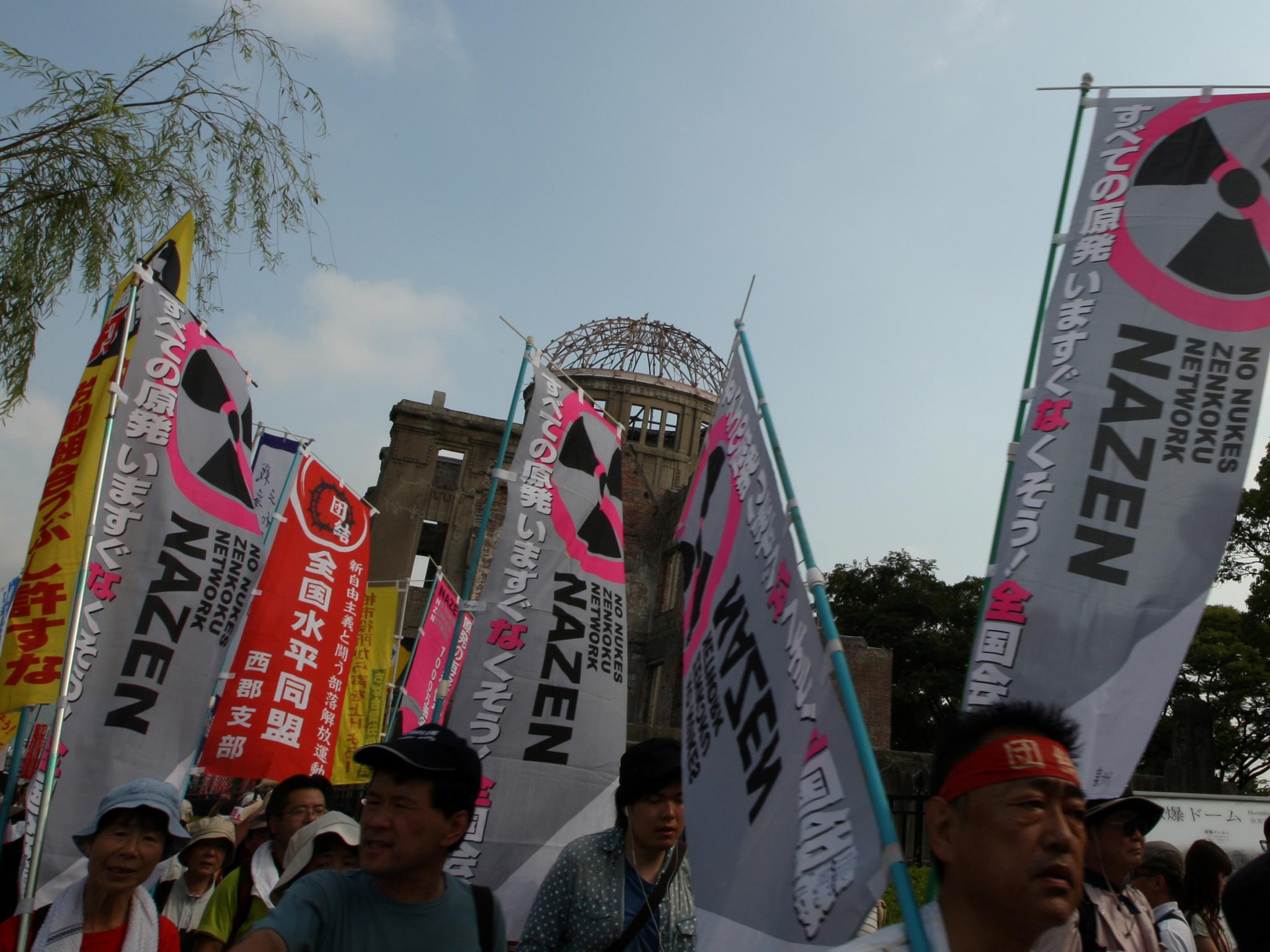 Anti-nuclear activists march in front of a Atomic Bomb Dome