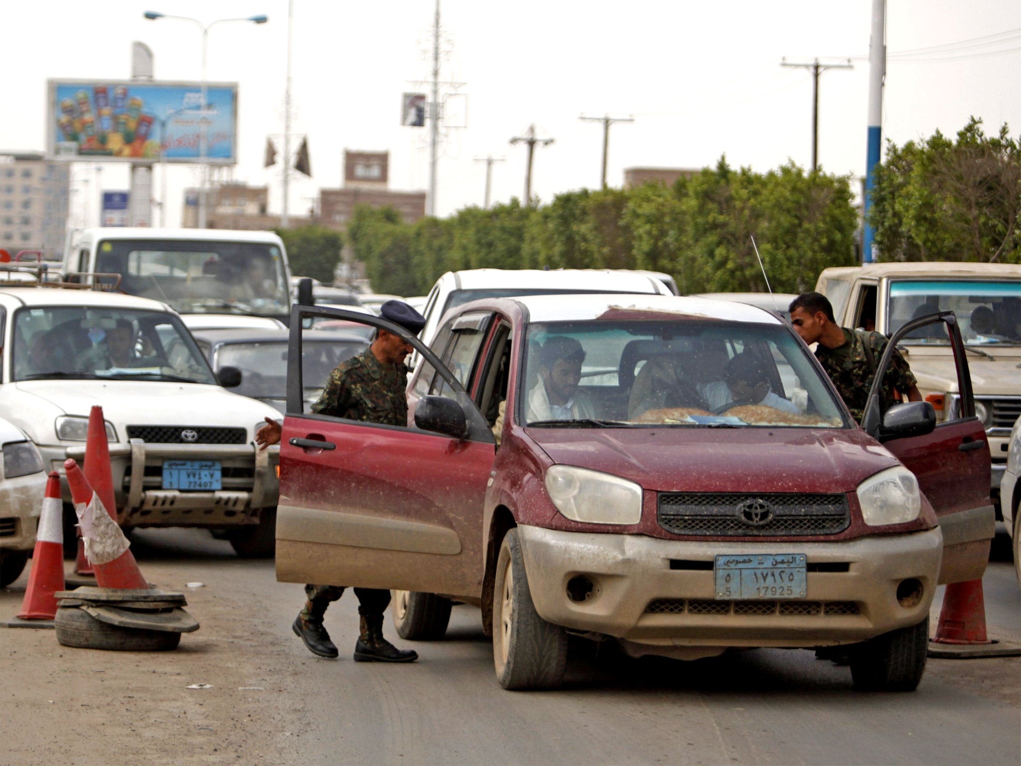 Police check cars on the road leading to the Sanaa Airport