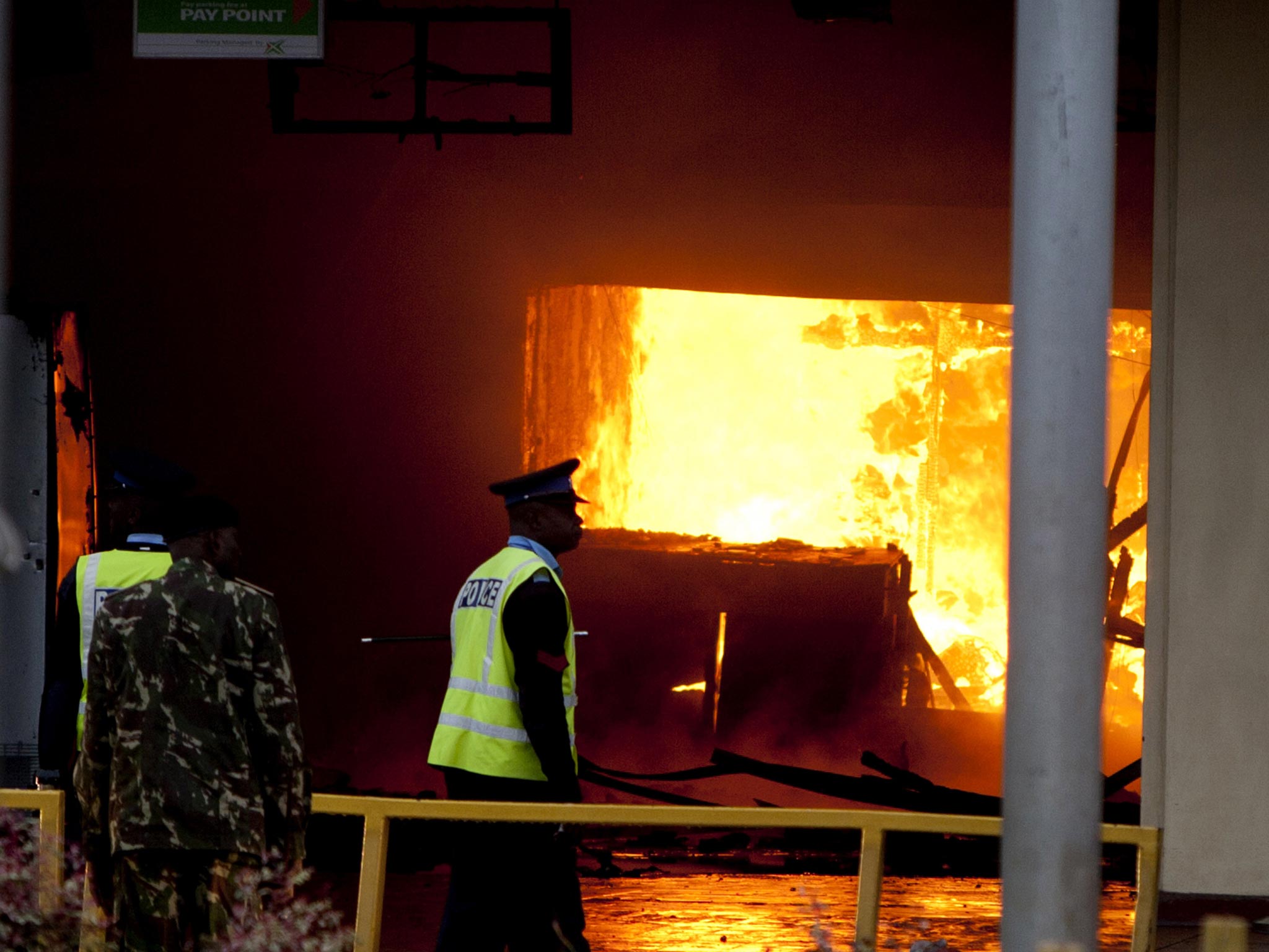 Policemen look at the fire near the international arrivals unit of Jomo Kenyatta International Airport, Nairobi, Kenya