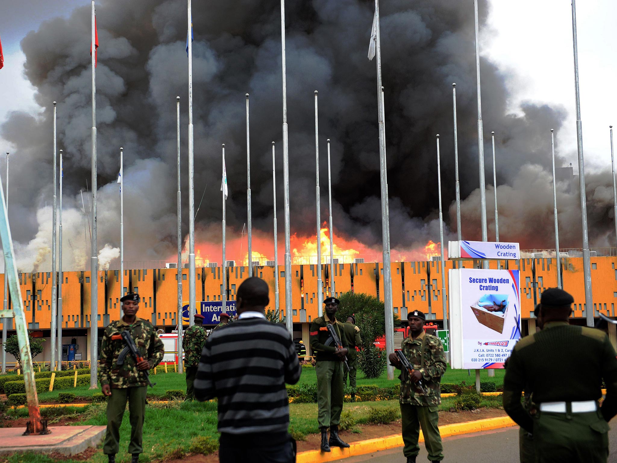 General Service (GSU) officer stand outside the burning Jomo Kenyatta international airport. A massive fire shut down Nairobi's international airport today with flights diverted to regional cities as firefighters battled to put out the blaze in east Afric