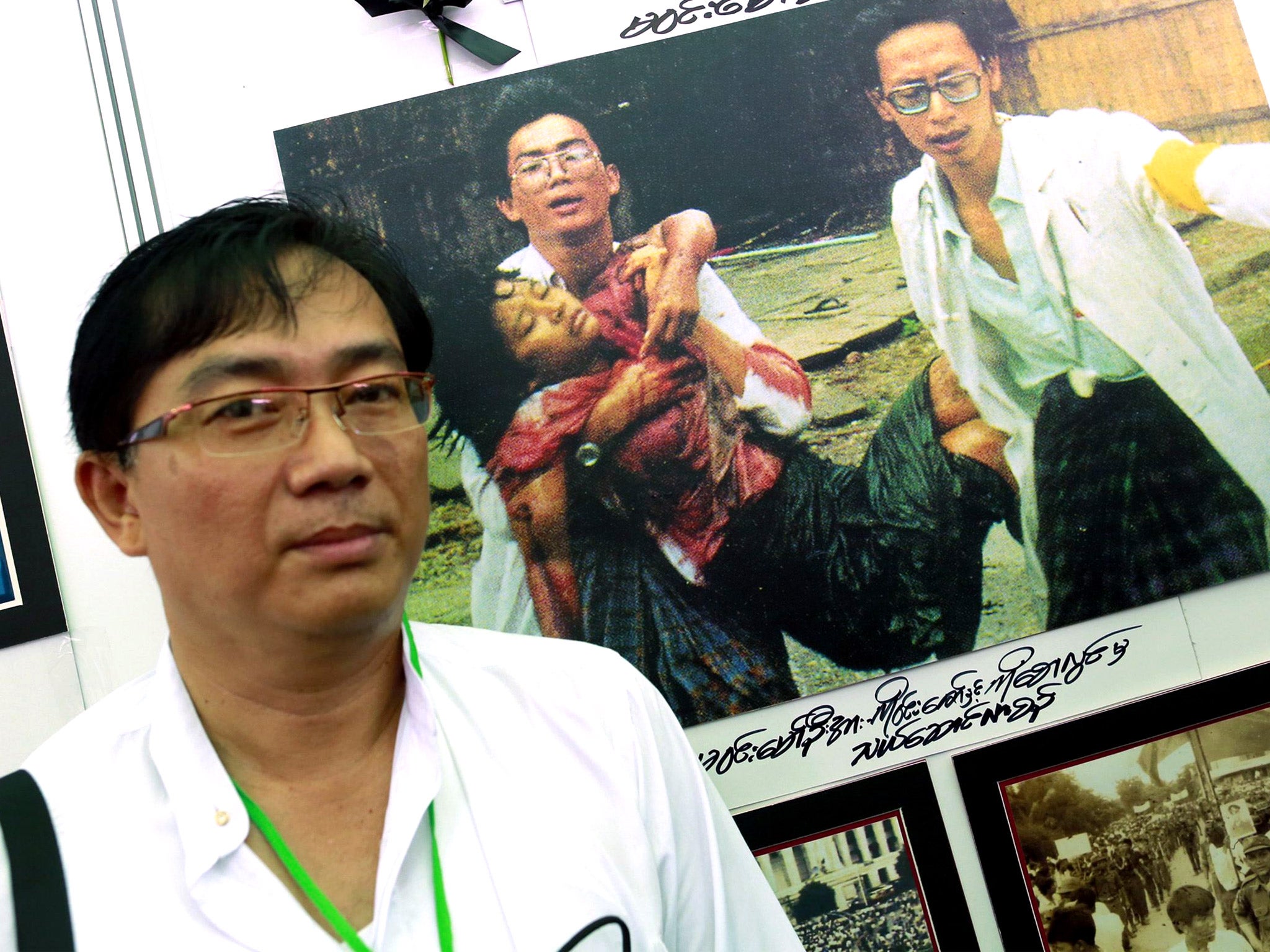 Dr Win Zaw visits an exhibition about the uprising, which features a picture of himself and another medic carrying an injured student