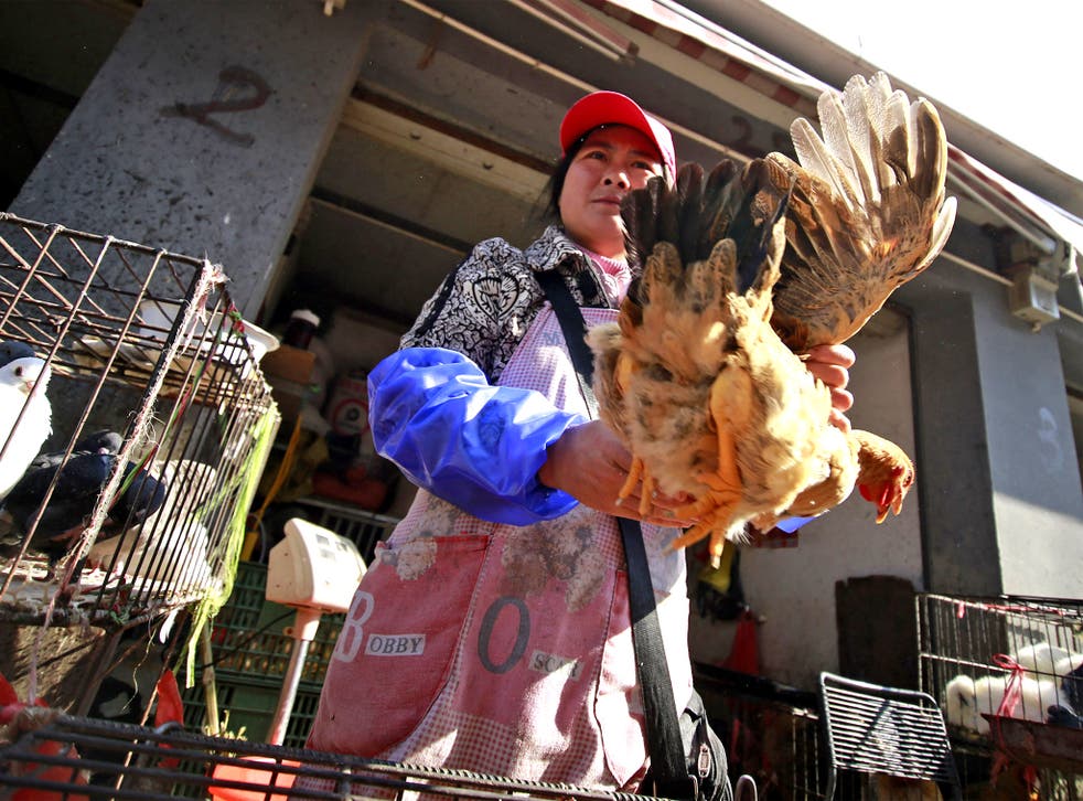 A vender sells chickens at market in Shanghai. The new H7N9 strain is thought to have infected at least 130 people in China
