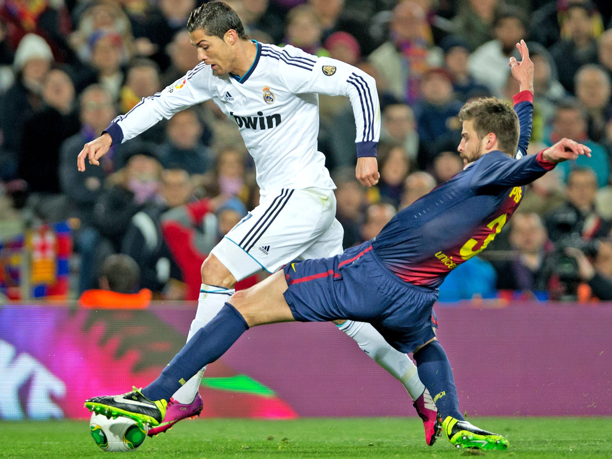Barcelona's Gerard Pique tackles Real Madrid's Christiano Ronaldo during a typically fiery encounter between the sides earlier this year