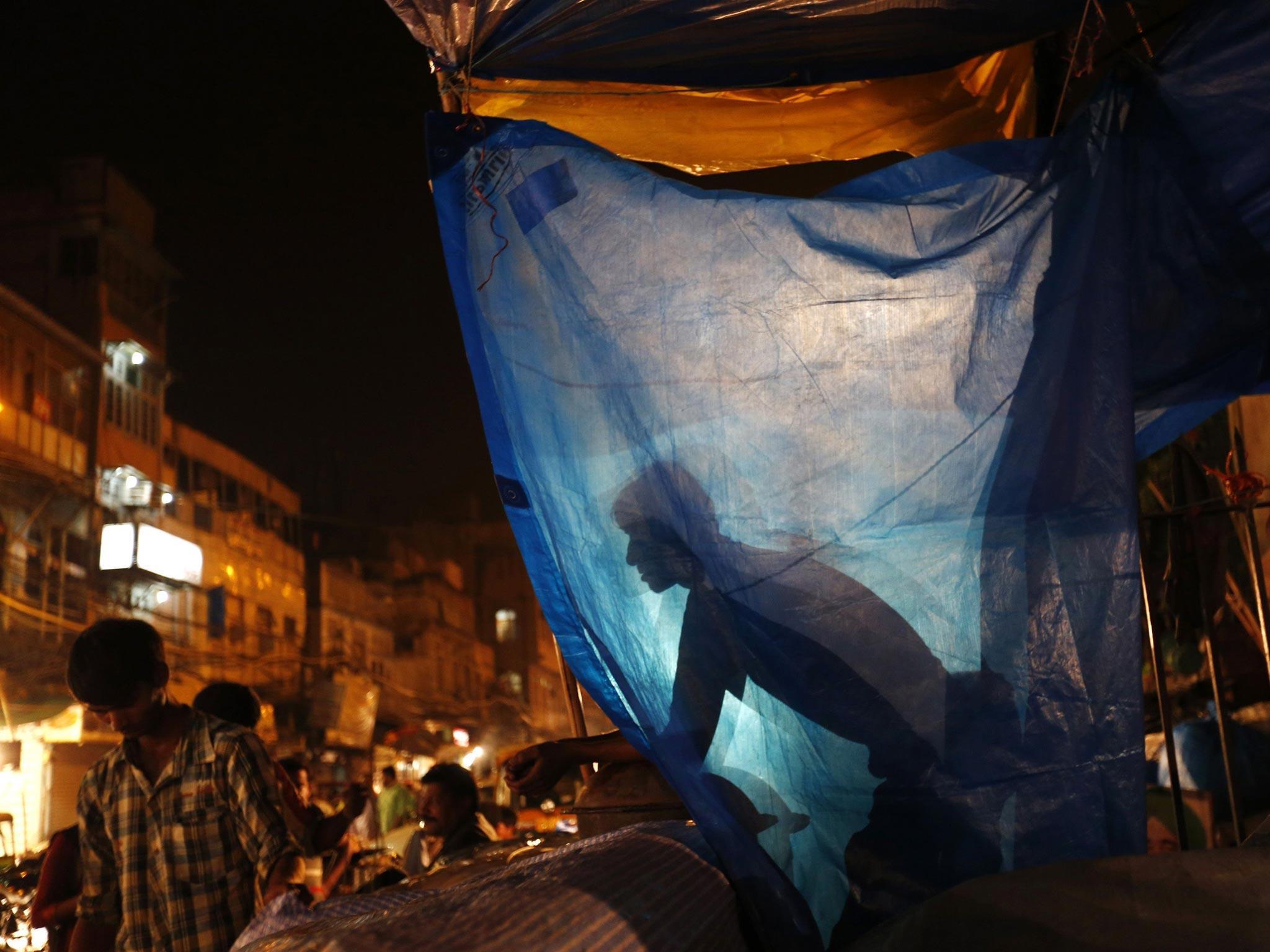 A vendor looks on from his stall after closing it ahead of Eid al-Fitr festival in Delhi
