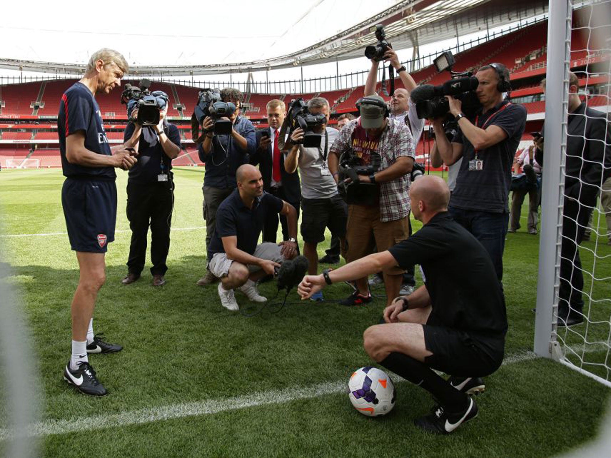 Arsenal manager Arsène Wenger watches referee Anthony Taylor demonstrate the Goal Decision System (GDS) at the Emirates yesterday