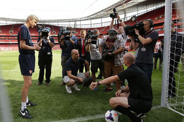 Arsenal manager Arsène Wenger watches referee Anthony Taylor demonstrate the Goal Decision System (GDS) at the Emirates yesterday