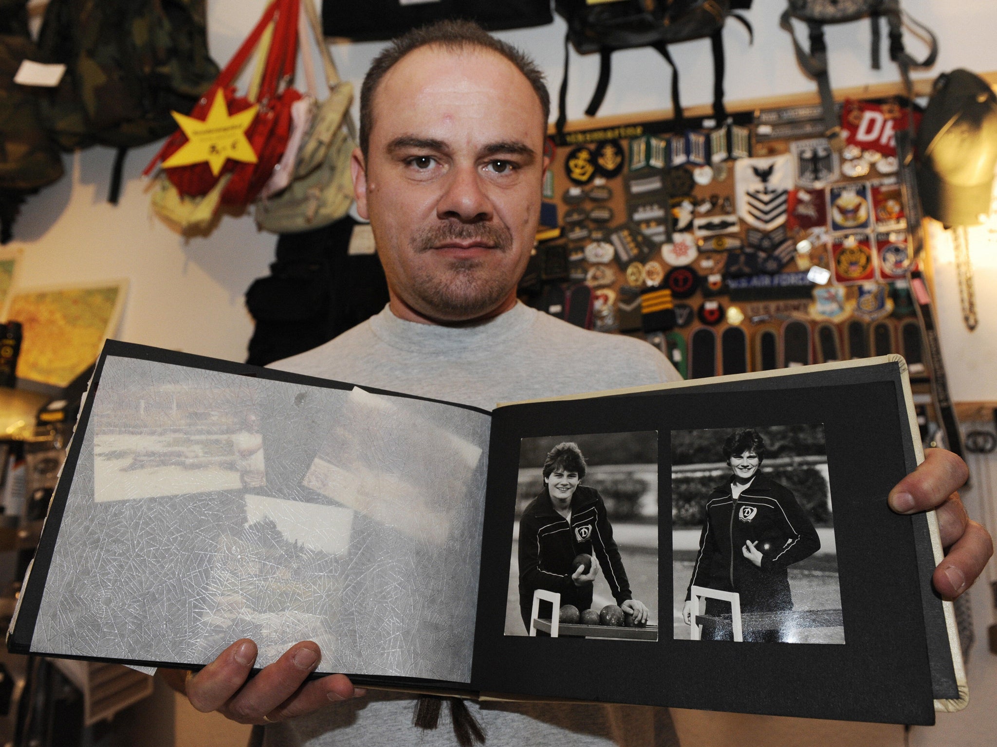 Former German shot putter Andreas Krieger, who competed as a woman (Heidi Krieger) on the East German athletics team, poses with a picture of himself in 1986-87)