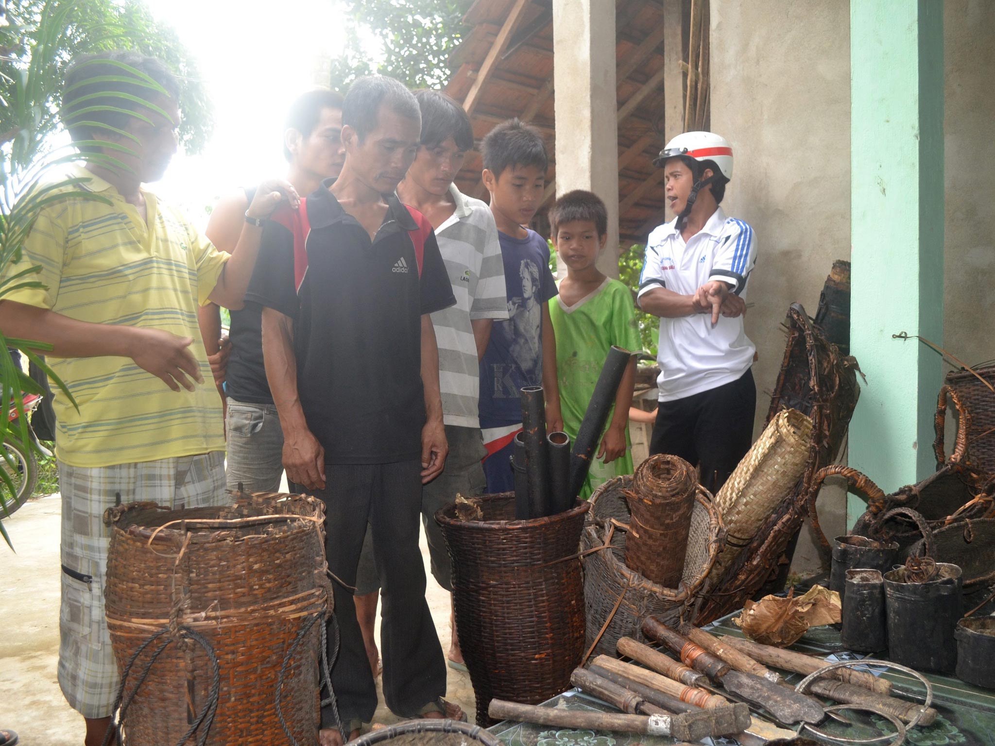 Local people examine the implements made by a Vietnamese father and his son