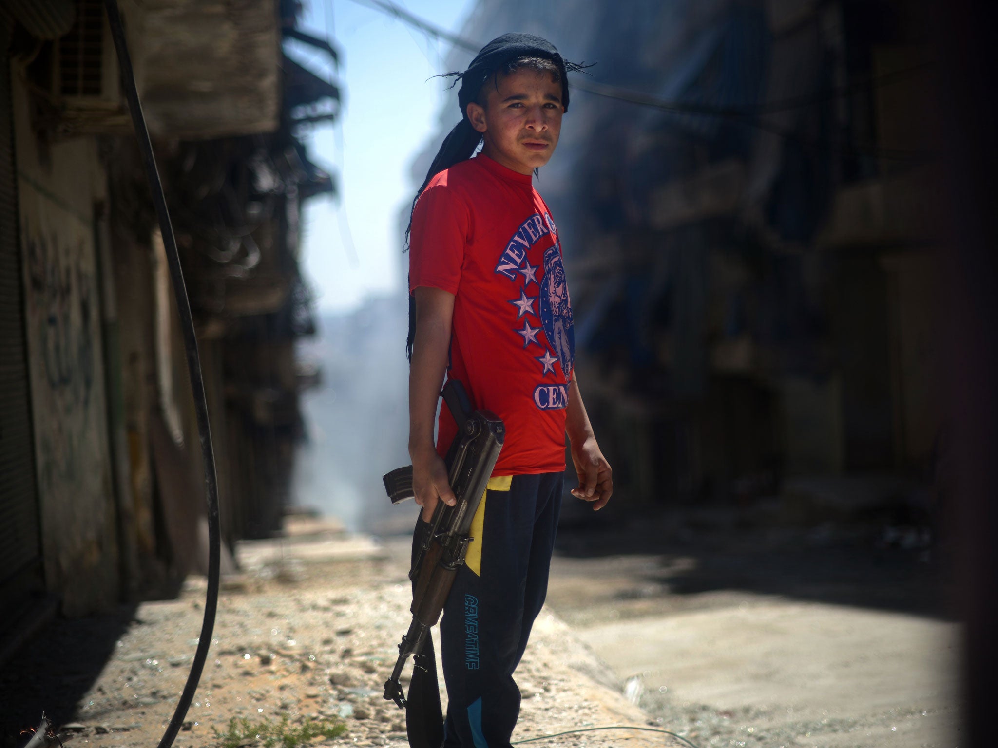 Boy soldier with an AK-47 on the streets of Aleppo, Syria