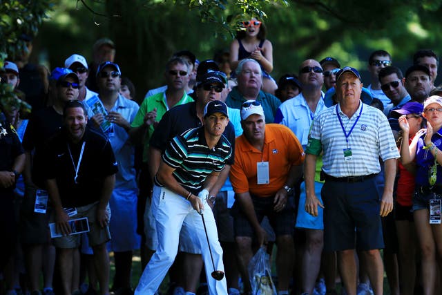 Rory McIlroy watches anxiously after playing out of the rough on the fourth hole