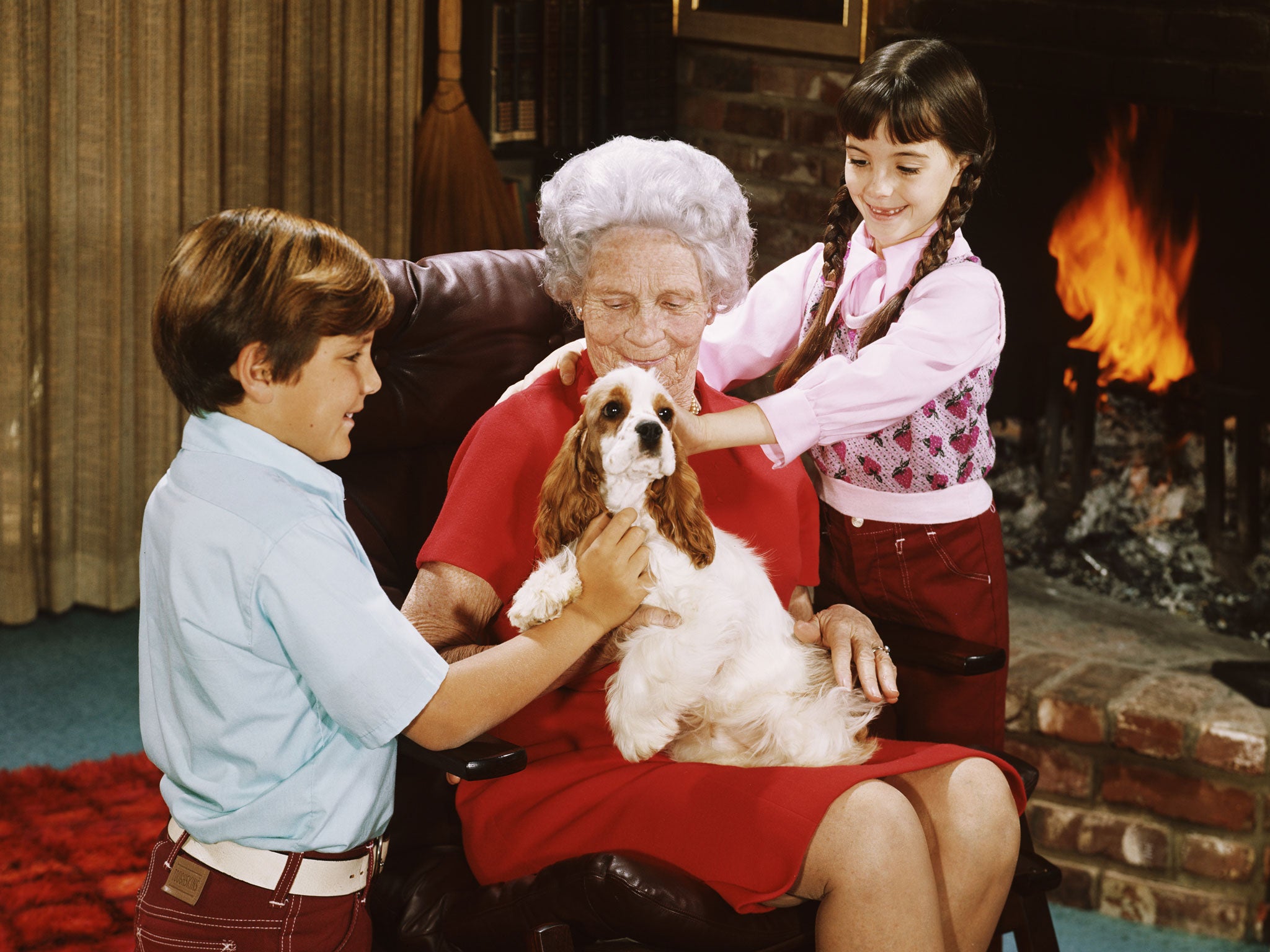 An elderly woman with her grandchildren and a pet spaniel, circa 1975.