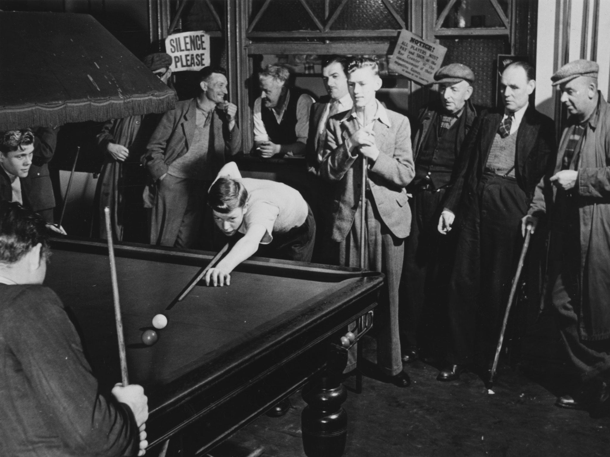 Young miners play billiards while their elders look on at the Workman's Institute in Gilfach Goch.
