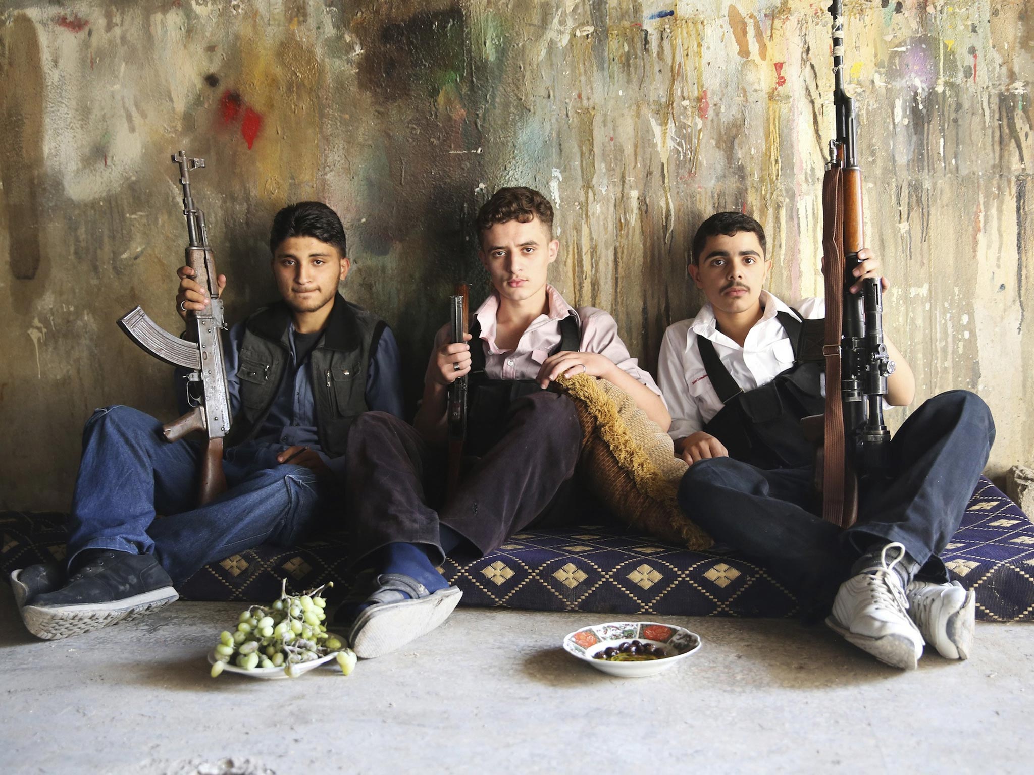 Free Syrian Army fighters hold their weapons as they pose for a picture in Jobar, Damascus